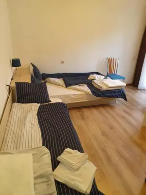 two beds in a room with wooden floors at THE CENTER Apartments Comfort 3 in Sandanski