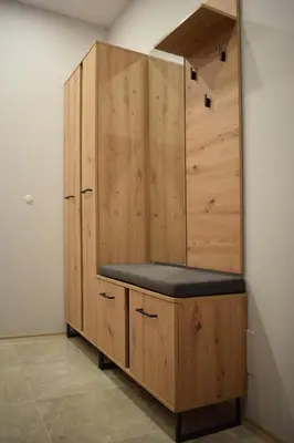 a wooden cabinet with a bench in a room at Pirotska 47 apartment in Sofia