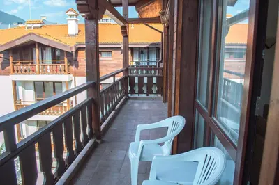 two white chairs on a balcony with a view at Winslow Infinity Aparthotel in Bansko