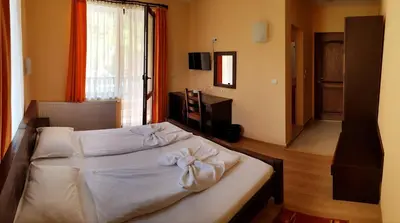 a bedroom with a bed with towels on it at Family Hotel Chiflik Hills in Chiflik
