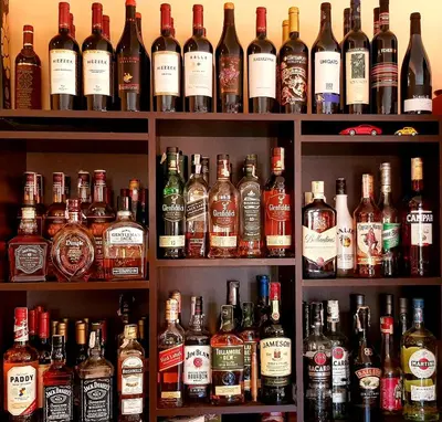 a shelf filled with lots of bottles of alcohol at Family Hotel Chiflik Hills in Chiflik