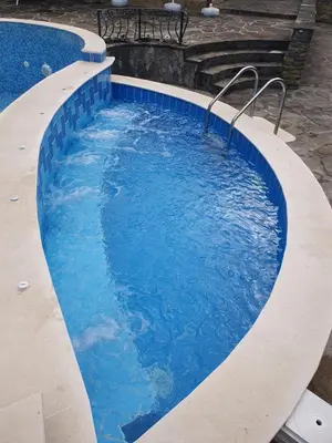 a large swimming pool with blue water at Family Hotel Chiflik Hills in Chiflik