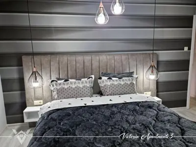 a bedroom with a large bed with gray stripes at Victoria apartments 3 in Velingrad