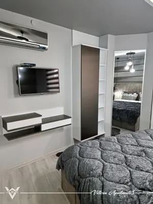 a bedroom with a bed and a tv on a wall at Victoria apartments 3 in Velingrad