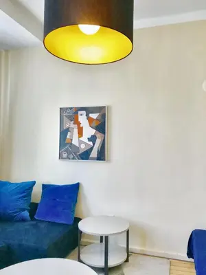 a living room with a blue couch and a yellow light at Charming Apartment Sofia 100m² in Sofia