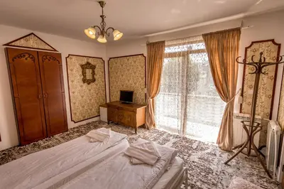 a bedroom with two beds and a television and a window at Tihiat Kut Complex in Kyustendil