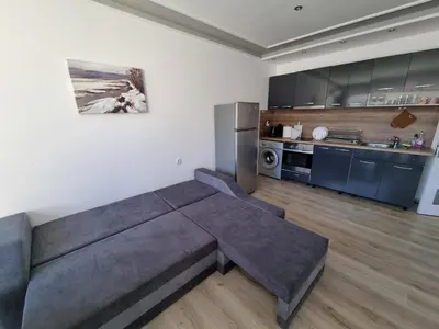 a living room with a couch and a kitchen at Luxury two bedroom Crown apartament in Botevgrad