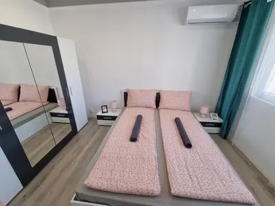 a room with two beds with pink cushions and a mirror at Luxury two bedroom Crown apartament in Botevgrad