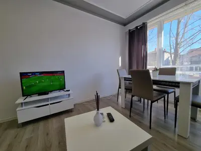 a living room with a television and a table with chairs at Luxury two bedroom Crown apartament in Botevgrad