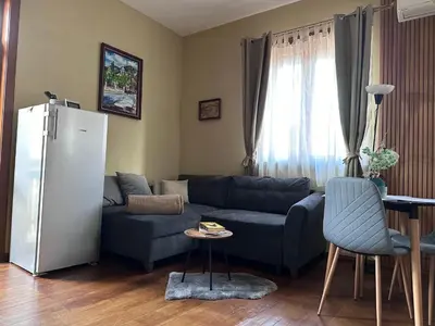 a living room with a blue couch and a refrigerator at Апартаменти за гости ,,Friends