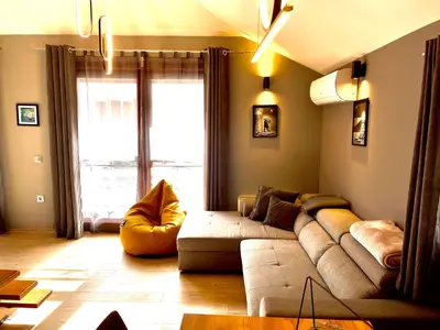 a living room with a couch and a large window at Апартаменти за гости ,,Friends