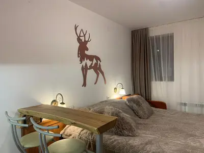 a bedroom with a bed with a deer on the wall at Bansko Ski To Door Studio De Luxe in Bansko