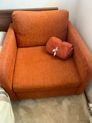an orange couch with a pillow on top of it at Bansko Ski To Door Studio De Luxe in Bansko