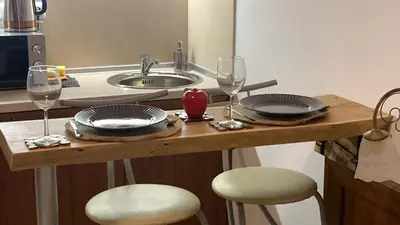 a table with two plates and wine glasses on it at Bansko Ski To Door Studio De Luxe in Bansko
