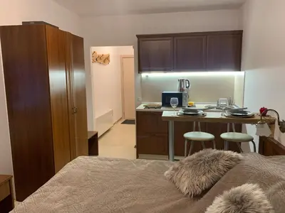 a bedroom with a bed and a kitchen with a table at Bansko Ski To Door Studio De Luxe in Bansko