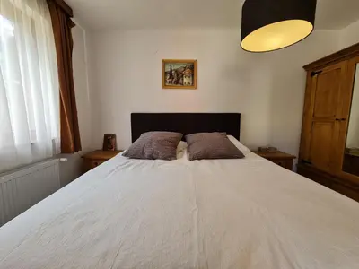a bedroom with a white bed with two pillows at Pirin Golf Apartment HOME with private garden in Bansko