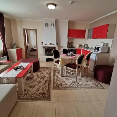 a living room with a table and chairs and a kitchen at Grand Monastery Pamporovo Apartment for rent in Pamporovo