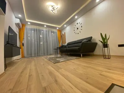 a living room with a couch and a clock on the wall at DV13 Luxury Suite Sofia Center in Sofia