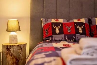 a bedroom with a bed and a table with a lamp at Studio 9, St John Park in Bansko