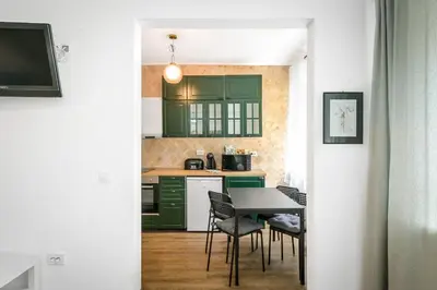 a kitchen with green cabinets and a table and chairs at Floral Studio Retreat in Sofia City Center by Flat Mаnager in Sofia