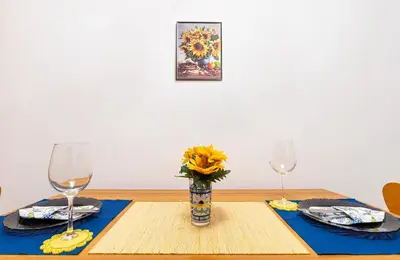 a table with two wine glasses and a vase with a sunflower at Lovely 1BD Apartment close to the Summer Theatre by Flat Mаnager in Plovdiv
