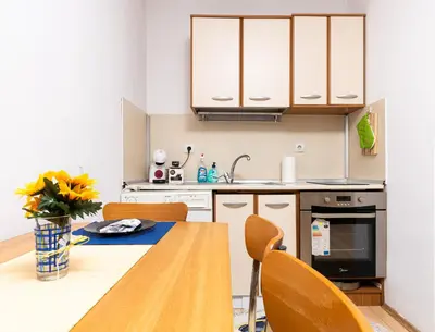 a kitchen with a wooden table with chairs and a sink at Lovely 1BD Apartment close to the Summer Theatre by Flat Mаnager in Plovdiv