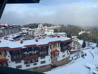 a town with snow on the roofs of buildings at GrandView Apartment Grand Monastery in Pamporovo