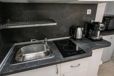 a kitchen counter with a sink and a stove at Paradise Apartment in Sandanski
