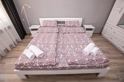 a bedroom with a bed with two pillows and avertisement at Paradise Apartment in Sandanski