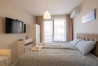 a bedroom with a large bed with a tv on it at Sunny Dream Apartments in Sofia