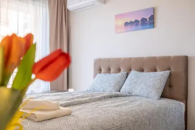 a bedroom with a bed with a vase of flowers at Sunny Dream Apartments in Sofia