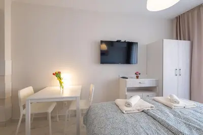 a bedroom with a bed and a table and a tv at Sunny Dream Apartments in Sofia