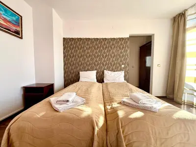 a bedroom with a large bed with towels on it at Family Hotel Carpe Diem in Banya