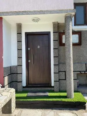 a wooden door on a house with grass at Апартамент Фреш in Velingrad