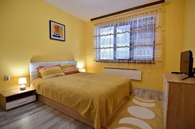 a bedroom with a large bed and a window at Апартамент Фреш in Velingrad