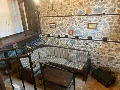 a living room with a couch and a table at Къща Александрова с басейн вътрешен и отопляем in Arda