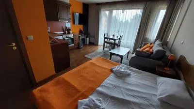 a bedroom with a bed and a living room at Сладко студио в Пирин с голф и СПА комплекс in Razlog