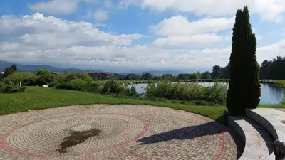 a circular stone walkway with a view of a lake at Сладко студио в Пирин с голф и СПА комплекс in Razlog