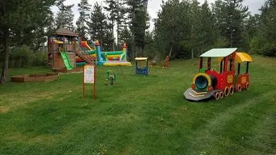 a childs playground with a train on the grass at Сладко студио в Пирин с голф и СПА комплекс in Razlog