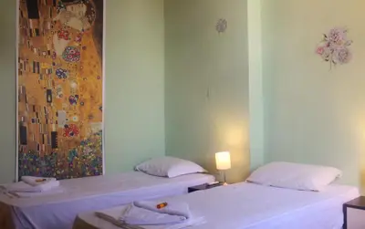 two beds in a room with a painting on the wall at Hotello in Sofia