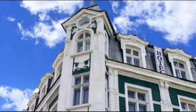 a white building with a clock on top of it at Hotello in Sofia