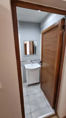 a bathroom with a sink and a wooden door at Родопска къща за гости с.ЧАЛА in Chala