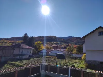 a sun shining in the sky over a town at Къща за гости Релакс-Рaдуил in Raduil