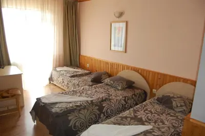 a hotel room with two beds and a window at Хотел Варненци in Lŭki