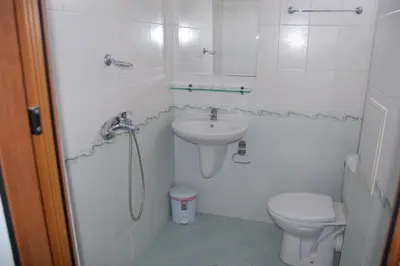 a white bathroom with a sink and a toilet at Хотел Варненци in Lŭki