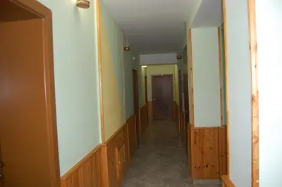 a hallway of a house with wooden walls and a door at Хотел Варненци in Lŭki