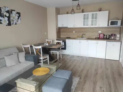 a living room with a couch and a table and a kitchen at Апартамент Четири сезона 2 in Velingrad