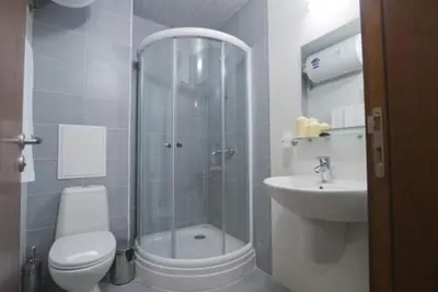 a bathroom with a shower and a toilet and a sink at 500м. от лифта Сладък дом в Белведере СПА комплекс in Bansko