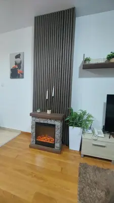 a living room with a fireplace in a room at 500м. от лифта Сладък дом в Белведере СПА комплекс in Bansko