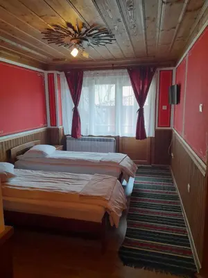 two beds in a room with red walls at Къща Ради in Koprivshtitsa